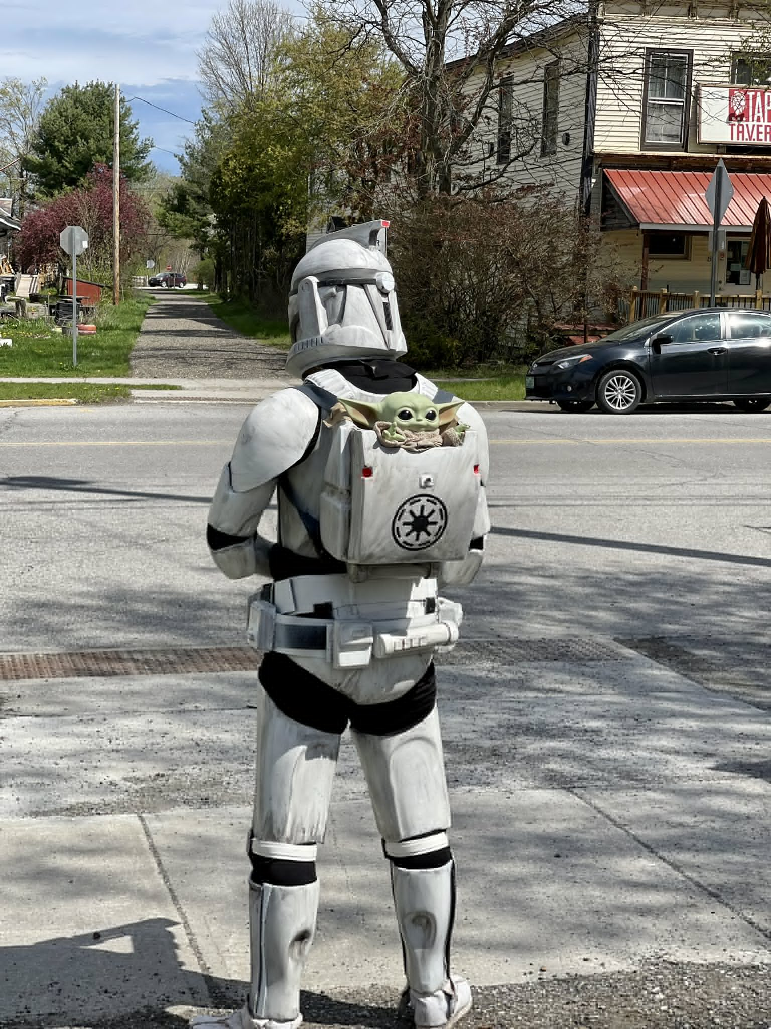 Picture: An AOTC Clone trooper facing away from the camera. A Baby Yoda is seated in the backpack.