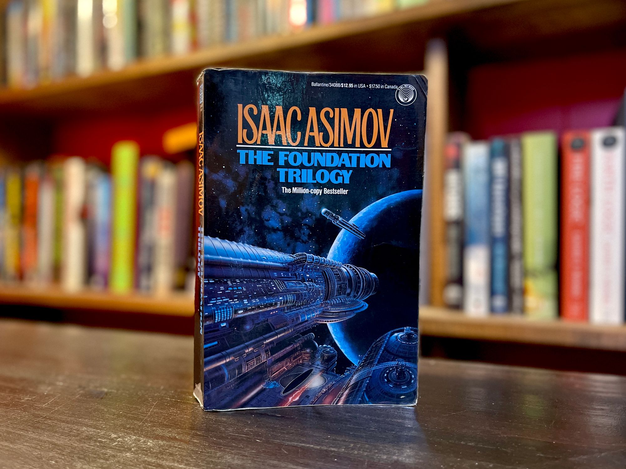 A copy of Isaac Asimov's Foundation, with a bookshelf in the background. 